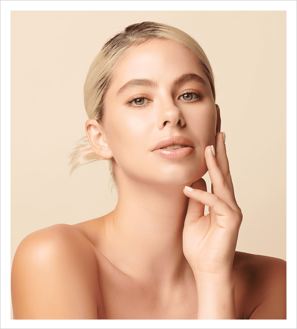 Close-up portrait of blonde woman touching face